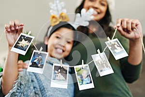 Decorate your home with happy family memories. a happy young mother and daughter hanging up family photographs during