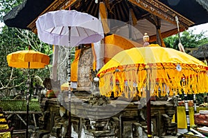 Decorated altar for celebration with textile and tedung umbrellas in Gunung Kawi, close to Ubud on Bali island, Indonesia