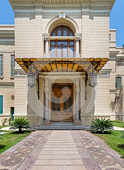 Decorated antique wooden door and window in a stone bricks wall, sunshade and lanterns, Abdeen Palace, Cairo, Egypt