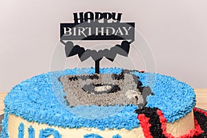 Decorated birthday cake with happy birthday stick pinned close up. Camera-themed round cake for the 31st birthday celebration for