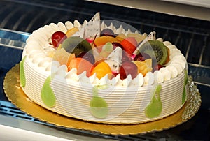 Decorated cake in refrigerated display unit of a bakery shop