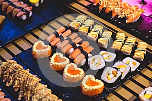 Decorated catering banquet table with different asian sushi rolls and nigiri sushi plate assortment on a party