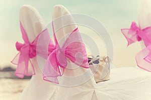 Decorated chairs with wedding arrangement on the beach