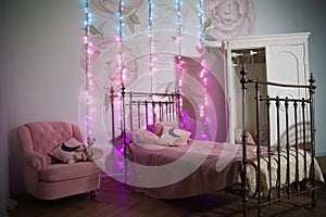 Decorated children`s room for Christmas. Bed, white wardrobe and chair, decorated for the New Year