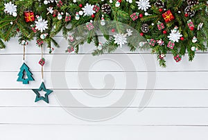 Decorated Christmas fir tree branch with on white wooden board background. Top view, copy space