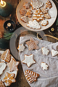 Decorated christmas gingerbread cookies on rustic table with napkin, candle, decorations, spices. Flat lay. Atmospheric moody