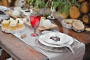 Decorated Christmas holiday table ready for dinner. Beautifully set with candles, spruce twigs, plates and serviettes