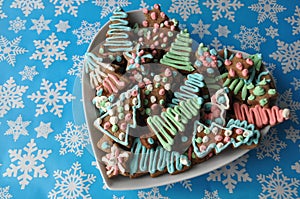 Decorated Christmas honey cookies on winter background with snowflakes