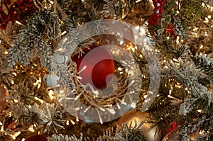Decorated Christmas tree closeup background. Red and silver balls and illuminated garland with flashlights. New Year