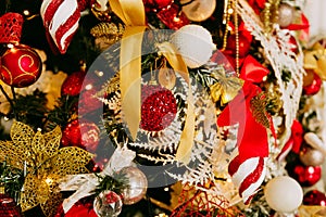 Decorated Christmas tree closeup. Red and golden balls and illuminated garland with flashlights