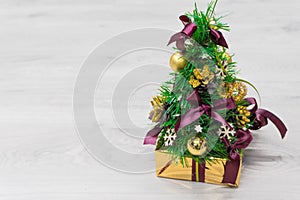 Decorated Christmas tree with golden patchwork ornament artificial gold balls and big gift presents for new year