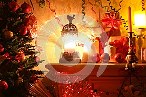 Decorated Christmas tree in the light of a lamp by the fireplace