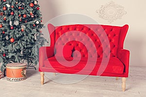 Decorated Christmas tree and a red sofa