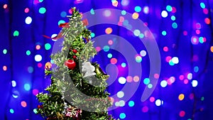 Decorated Christmas tree rotating on blinking background