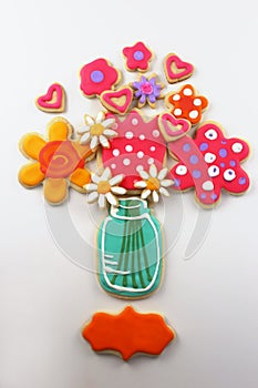 Decorated cookies forming a bouquet of flowers in a mason jar