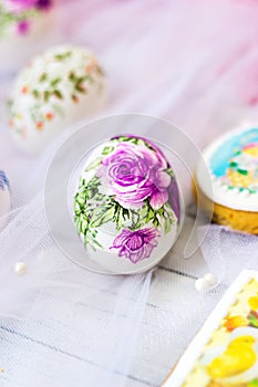 Decorated easter eggs and cookies on white tulle background; decoupage technique