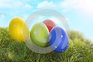 Decorated easter eggs in grass on sky background
