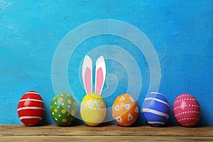 Decorated Easter eggs on table near color wall.