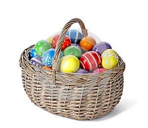 Decorated Easter eggs in wicker basket on white