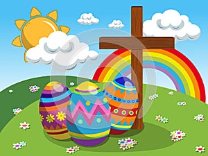 Decorated eggs and christian cross at easter meadow