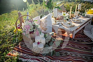 Decorated elegant wooden table in rustic style with eucalyptus and flowers, porcelain plates, glasses, napkins and cutlery