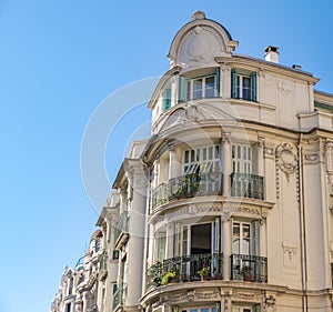 Decorated facade of a historic house in Nice, France. You can see the typical windows, balconies and shutters of a Mediterranean c