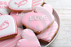 Decorated heart shaped cookies on white wooden table, closeup. Valentine`s day treat