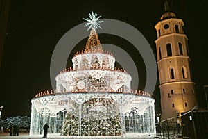 Decorated and illuminated Christmas tree on the Cathedral Square at night in Vilnius. Celebrating Christmas and New Year in