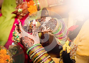 Decorated Indian bride holding candle in her hand. Focus on Hand.