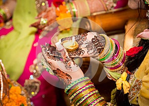 Decorated Indian bride holding candle in her hand. Focus on Hand.