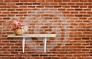 Decorated interior on shelf with flower. Red brick wall texture background