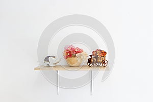 Decorated interior on shelf, put flower, wooden bowls and elephant made of ceramic