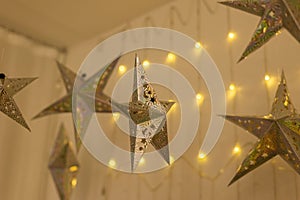 Decorated lighting golden stars and big red Christmas balls hanged on ceiling in the room for ready on the Christmas night party