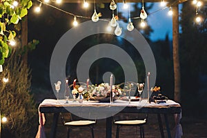 Decorated outdoor wedding table with flowers in rustic style