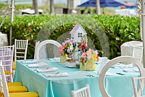 Decorated party table setting with bird house and flower arrangements in polka dots jars