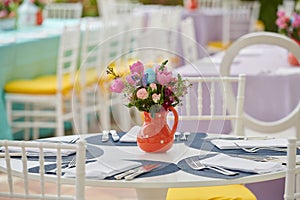 Decorated party table setting  flower arrangements in polka dots jar