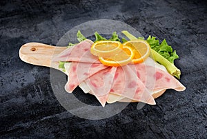 Decorated pizza ham sliced and vegetables on kitchen board with