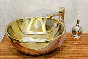 A decorated sink in gold color in a public toilet