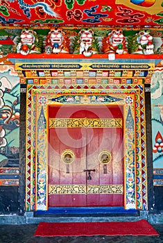 Decorated, with a skillfully made and ornate doorknobs entrance to a temple of the Rumtek Buddhist monastery photo
