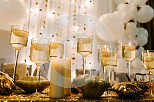 Decorated table for wedding. White balloons, candles, autumn leaves and small pumpkins. Autumn location and Halloween decor.