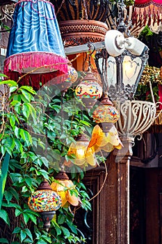 decorated terrace of the cafe, facade is decorated with different chandeliers.