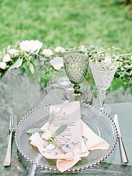 Decorated wedding table with beautiful flower composition, glass for wine and plate, outdoor, fine art.