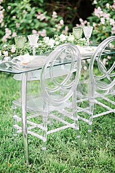 Decorated wedding table for two with beautiful flower composition of flowers, glasses for wine, outdoor, fine art.