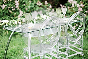 Decorated wedding table for two with beautiful flower composition of flowers, glasses for wine, outdoor, fine art.