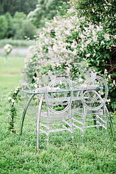 Decorated wedding table for two with beautiful flower composition of flowers, glasses for wine, outdoor, fine art.