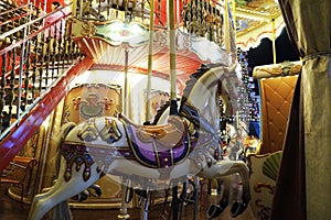 decorated white horse on a lighted children's carousel