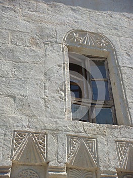 Decorated white window with some graven sketches to Mustafapasa in Cappadocia, Turkey.
