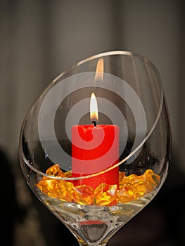 Decorating asymetrical glass with lit candle and yellow decorating glass