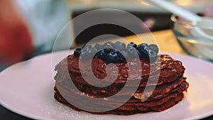 Decorating a chocolate cake with blueberries