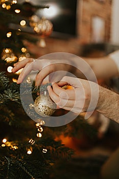 Decorating Christmas tree on bright background. Family decorating for Christmas
